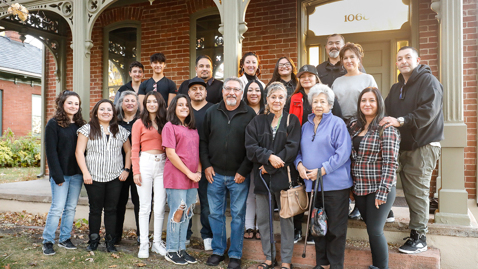 Families of displaced Aurarians, in front of a historical row home on 9th St.