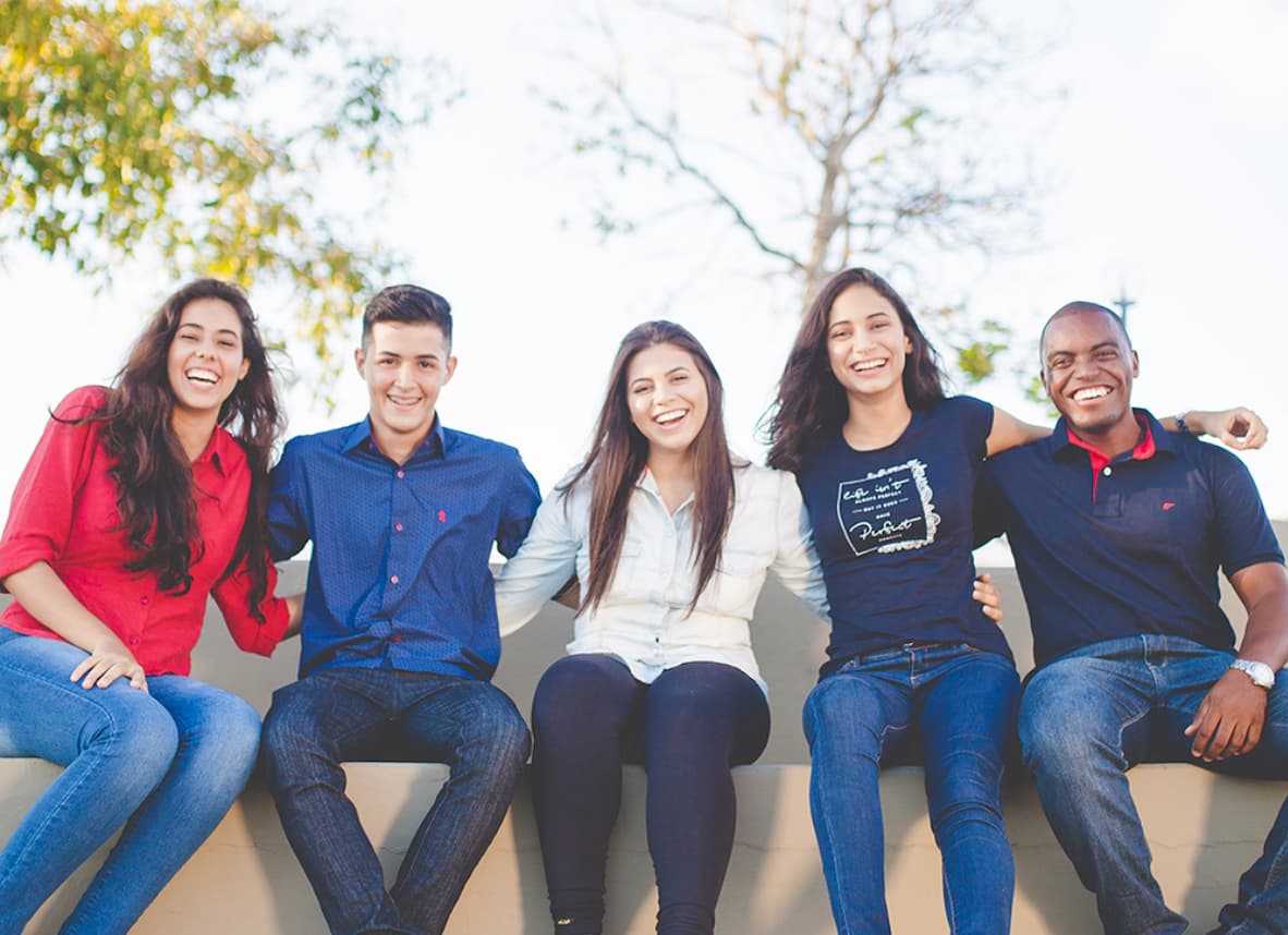 Group of students sitting on bench.