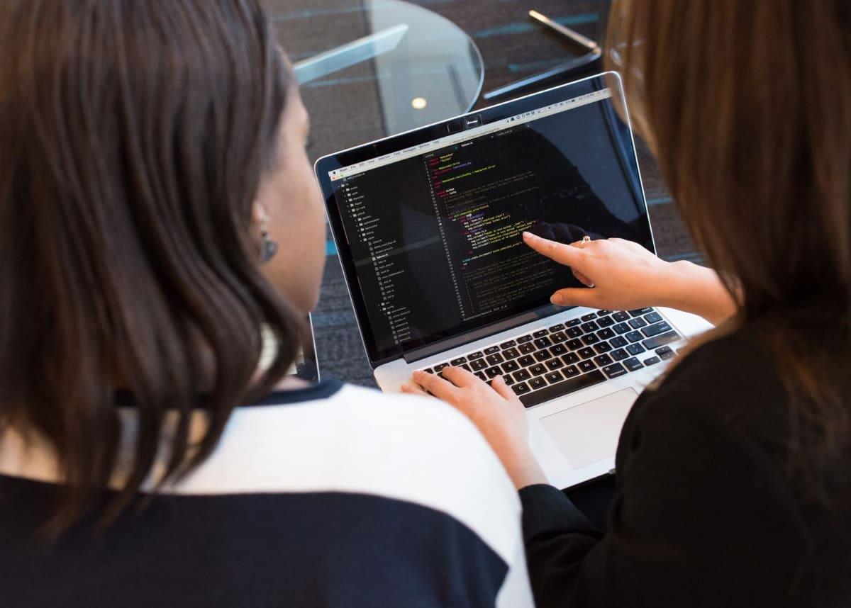 two women sitting at computer looking at data