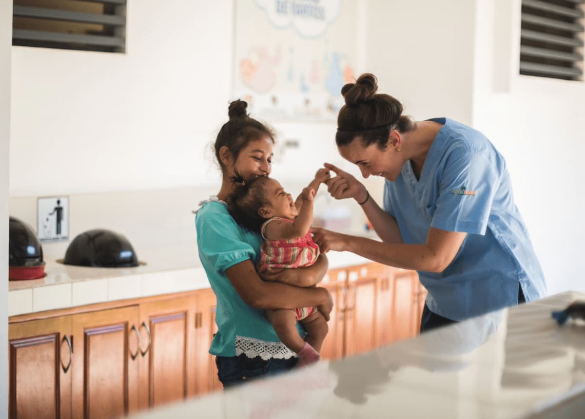 doctor helping baby and mother