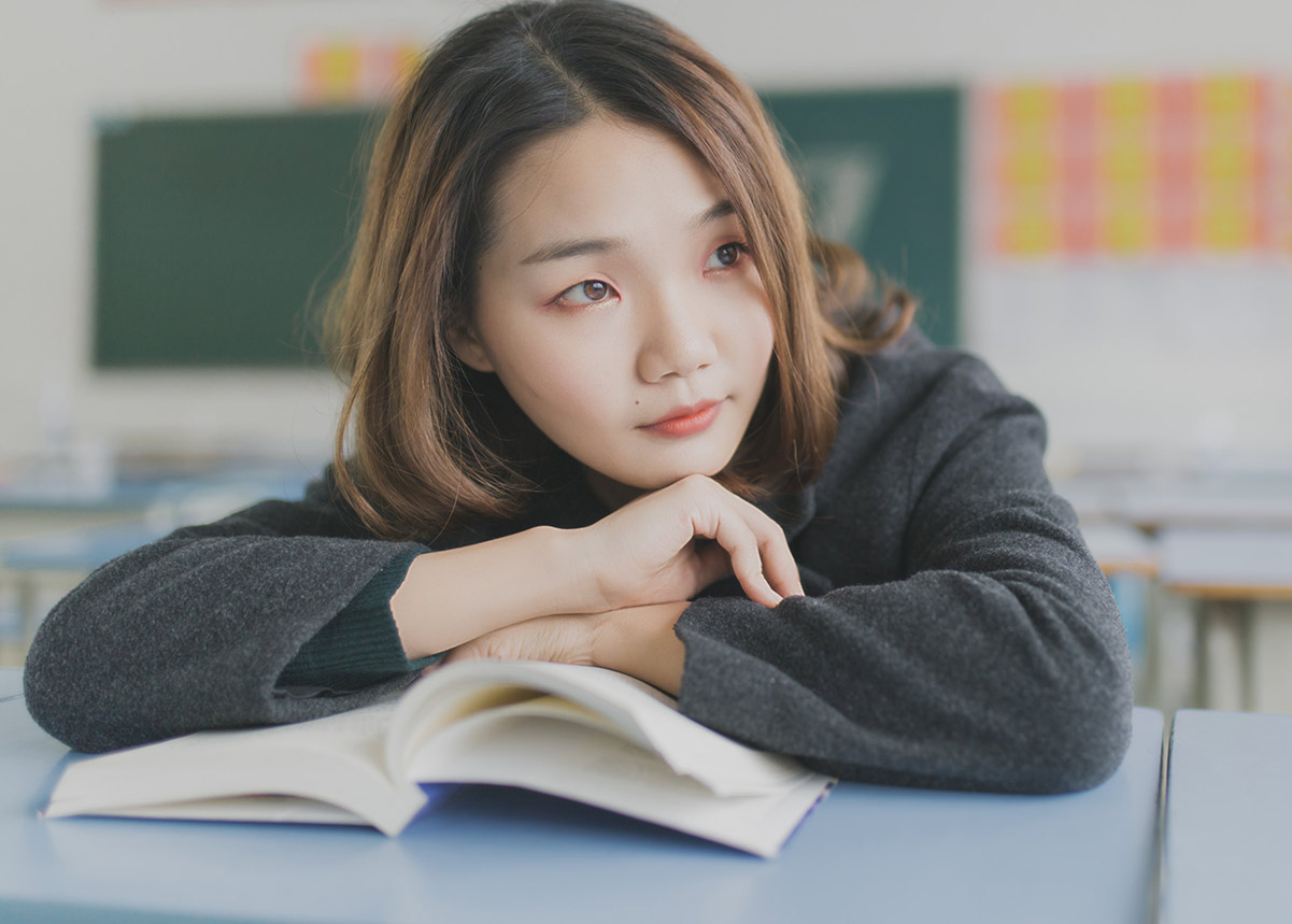 woman resting her head on an open book