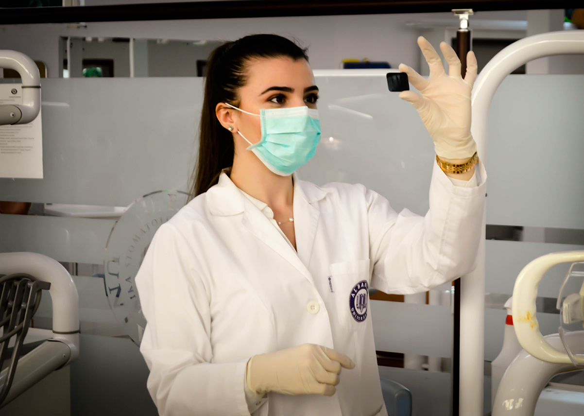 healthcare worker wearing a face mask holding and examing something