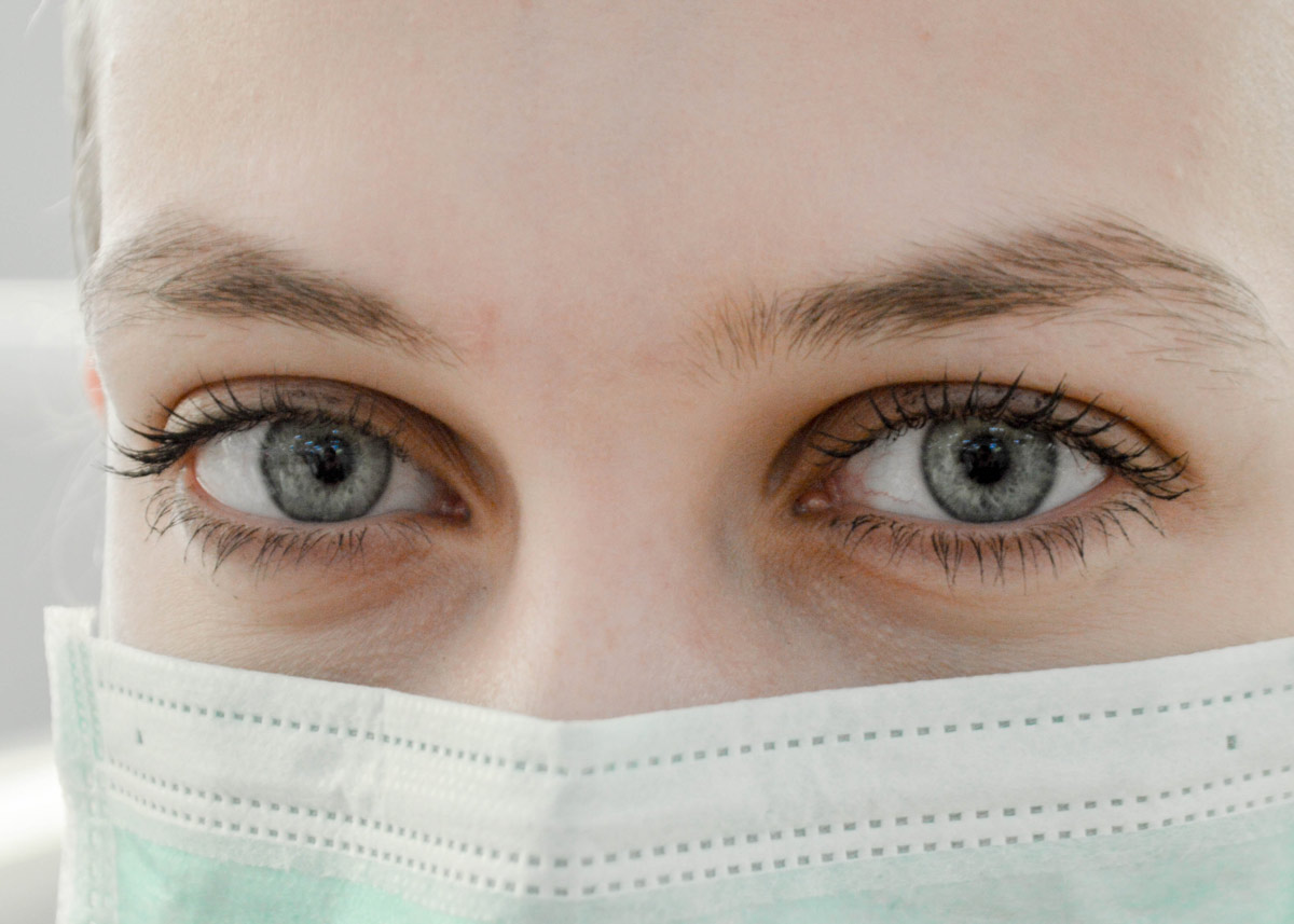 close up of person's eyes and them wearing a facemask