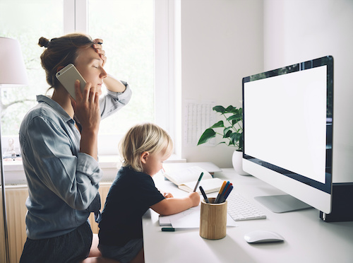 Working mother on the phone with a child on her lap