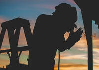 silhouette of worker drilling