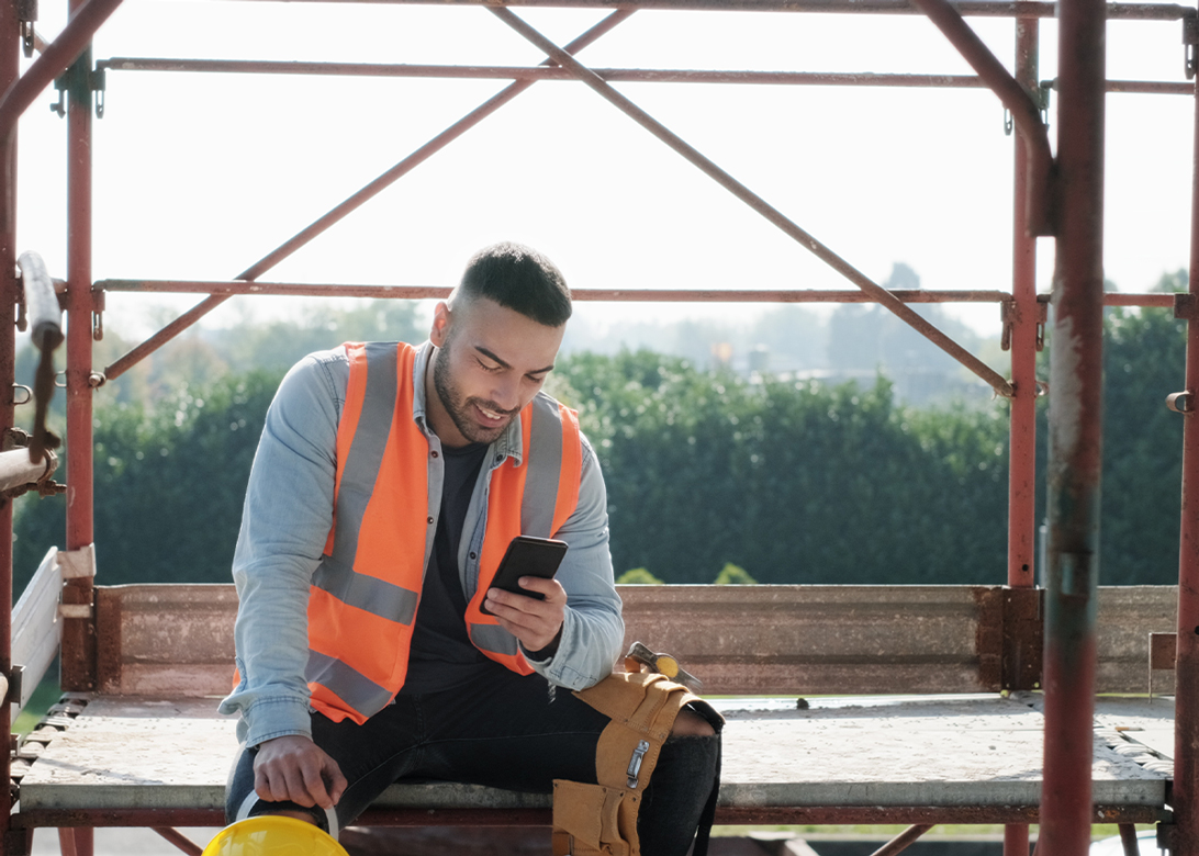 Man in construction looking at his phone