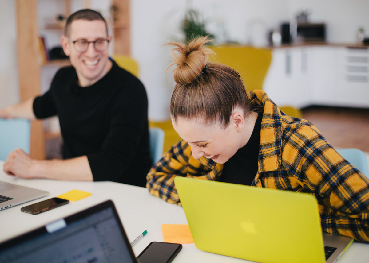 two workers sitting together and laughing