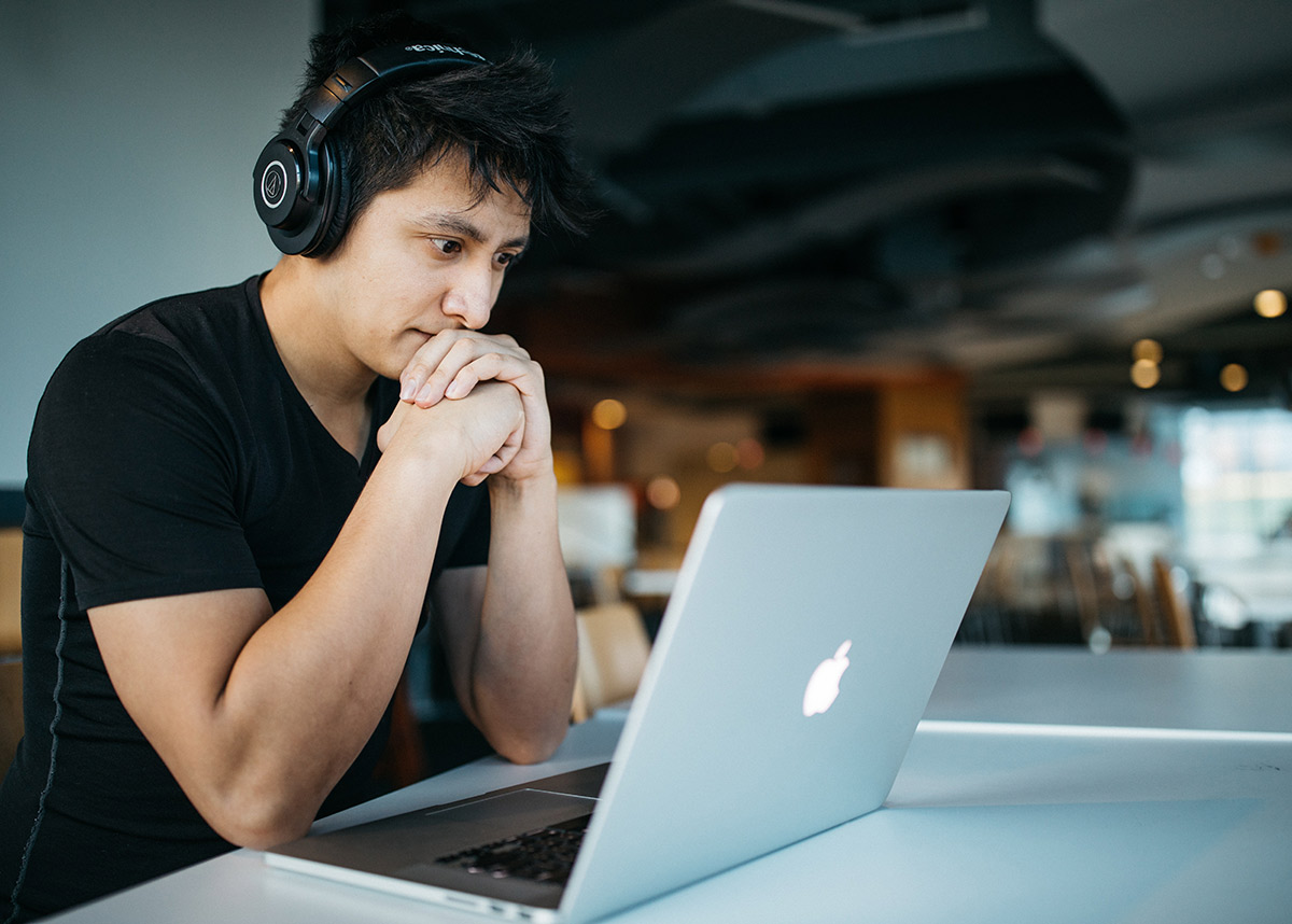 man at a computer wearing headphones