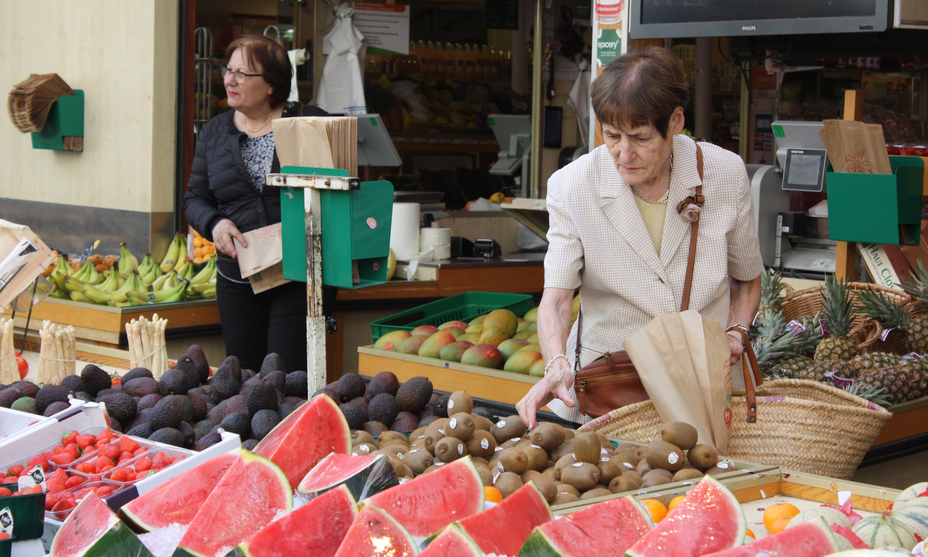 woman picking fruit from stand