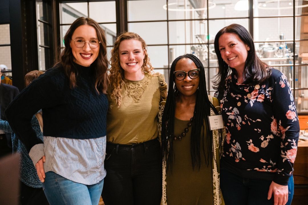 four women standing together at event