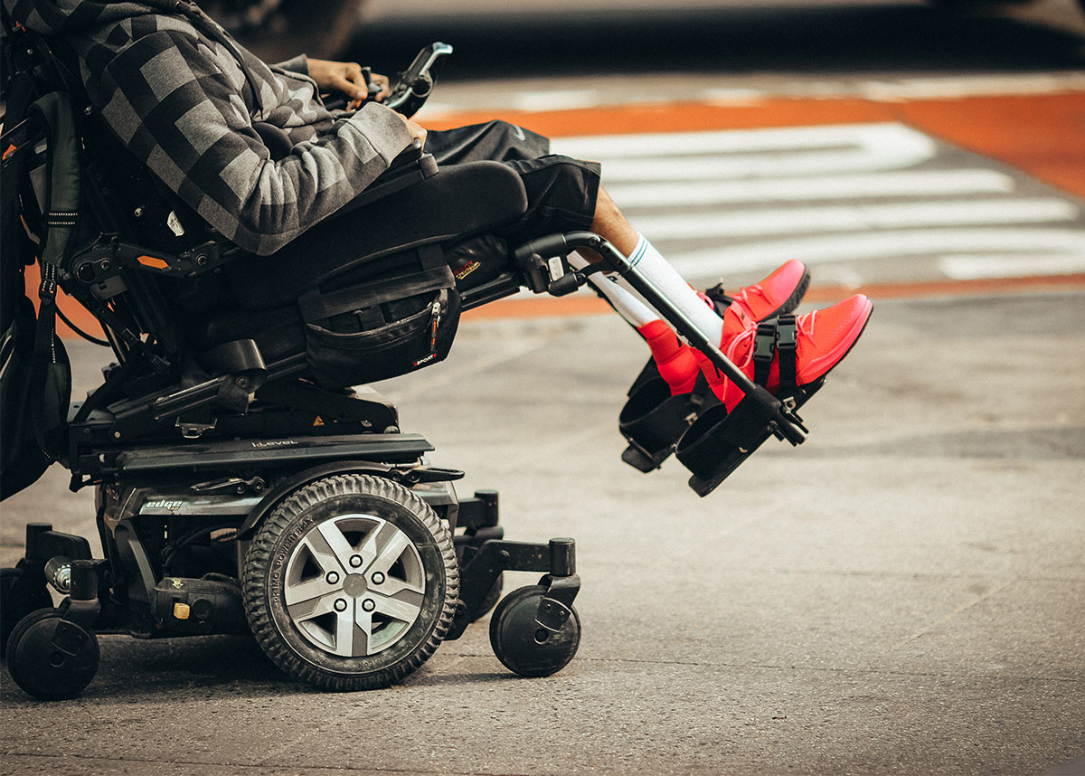 Person who is disabled using a wheelchair outdoors