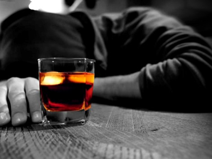 person laying on table with glass of alcohol