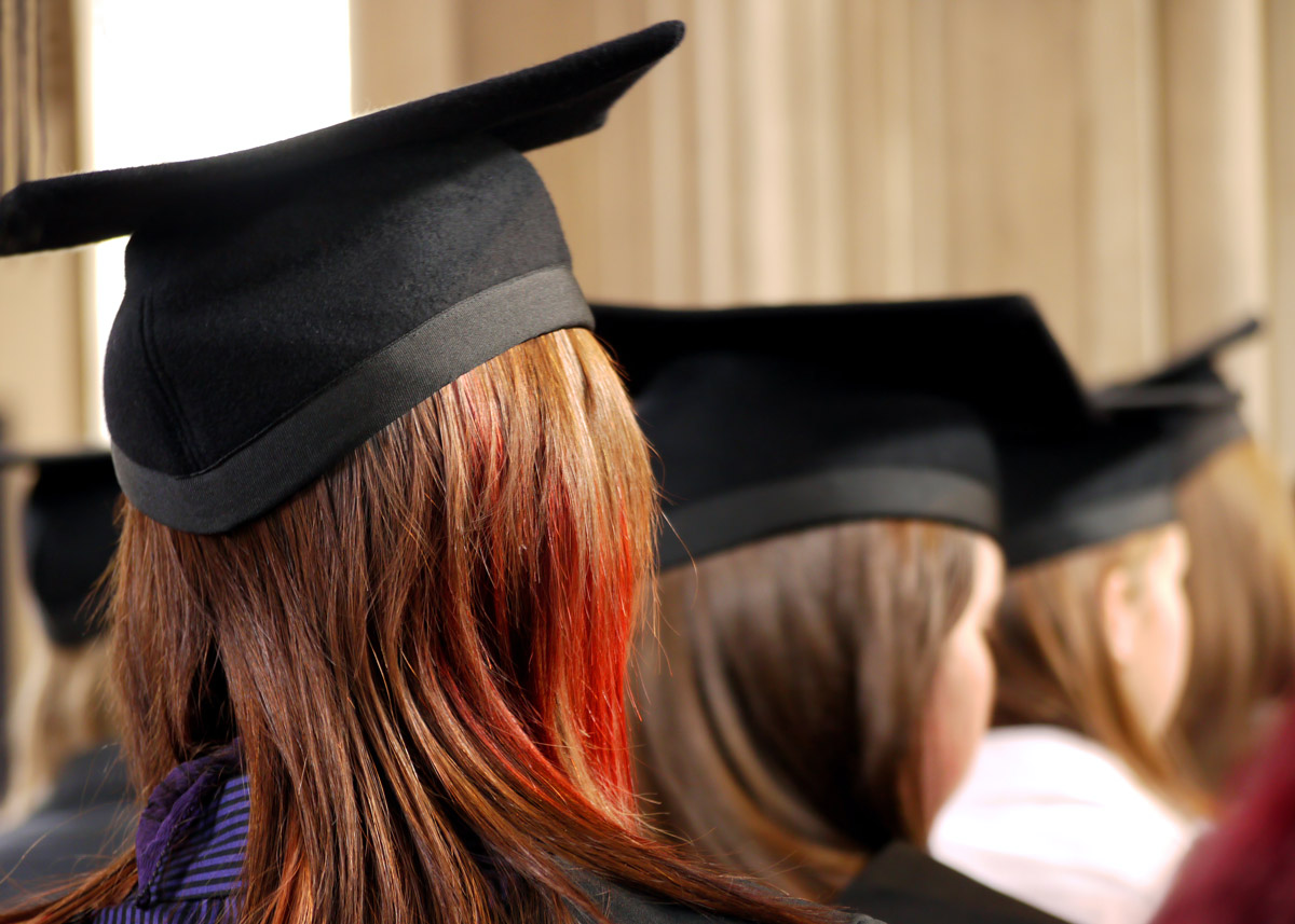 back of students' heads in graduation caps