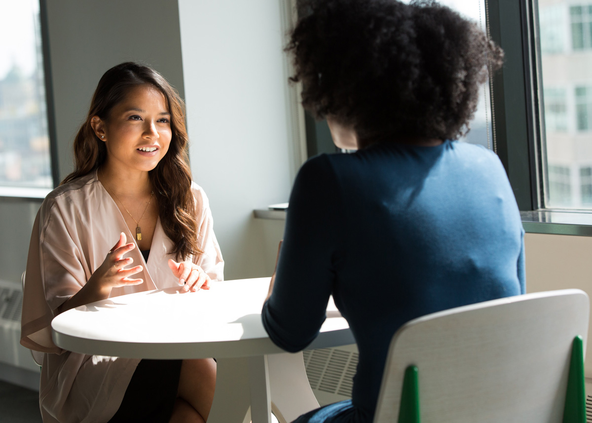 two women talking at a table