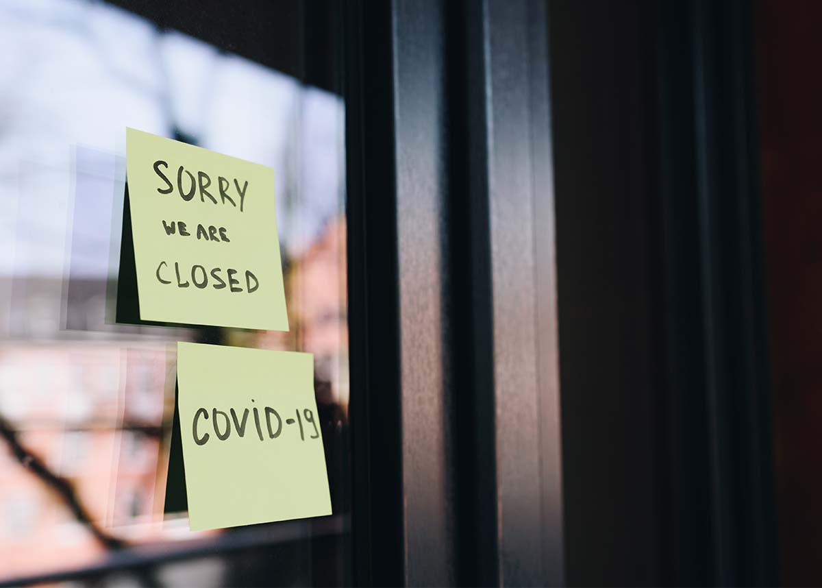 Two sticky notes on the door of a business that read 