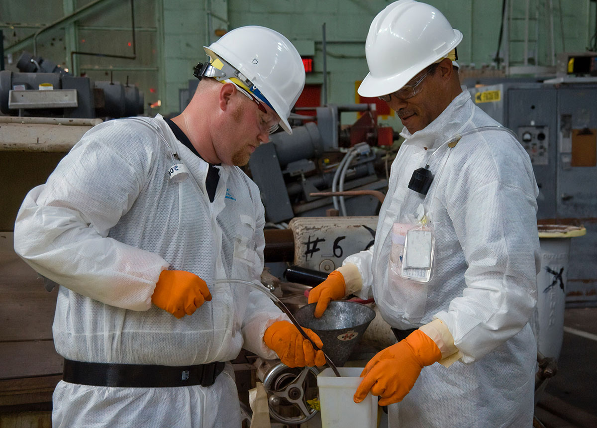 two workers in hard hats and protective gear