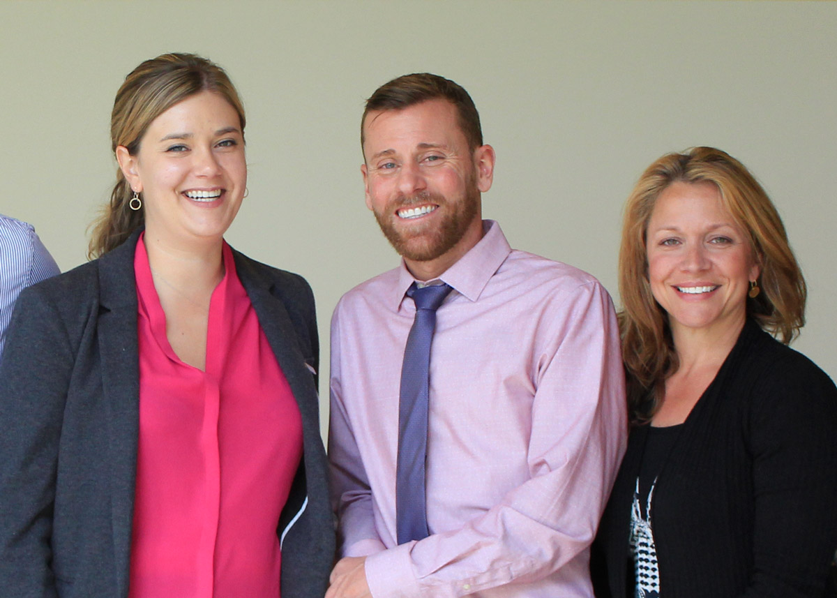 Three staff members smiling