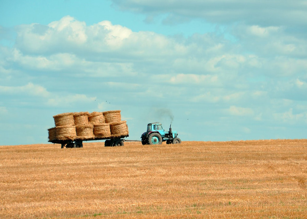 tractor in a field with hay on the back