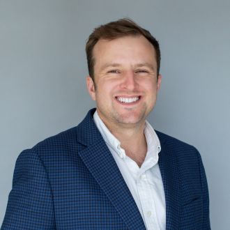 Headshot of man wearing blue plaid suit