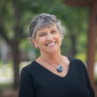 Headshot of woman with short hair wearing necklace