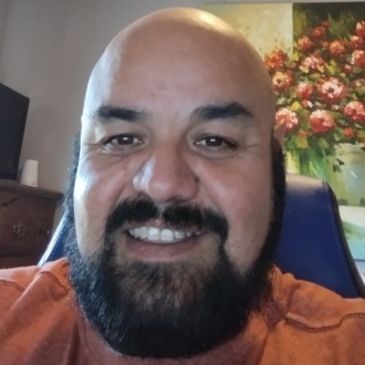 Man with a beard smiling in headshot