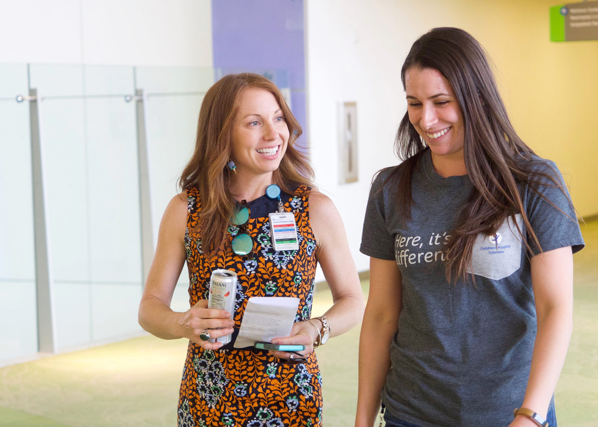 Alum Katherine O'Connor walking and smiling with a colleague