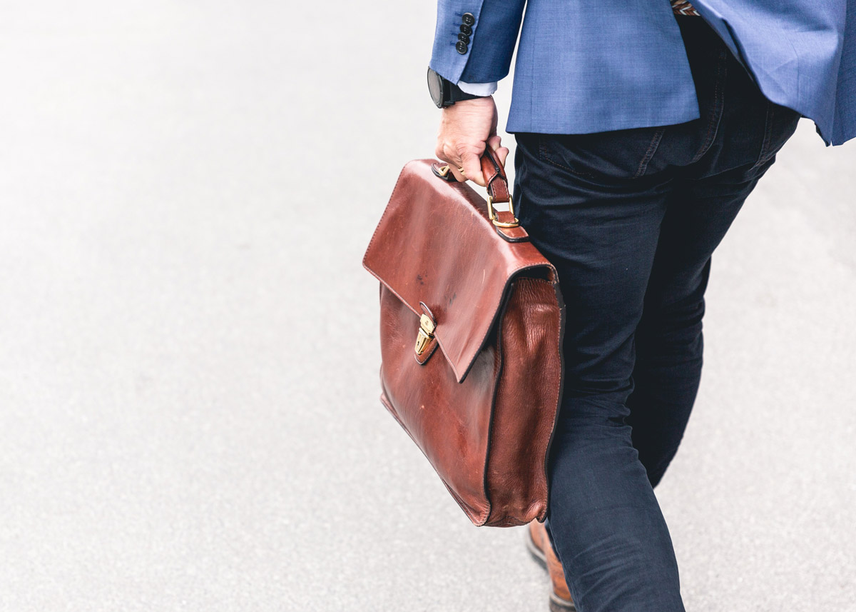 person walking with a briefcase in hand