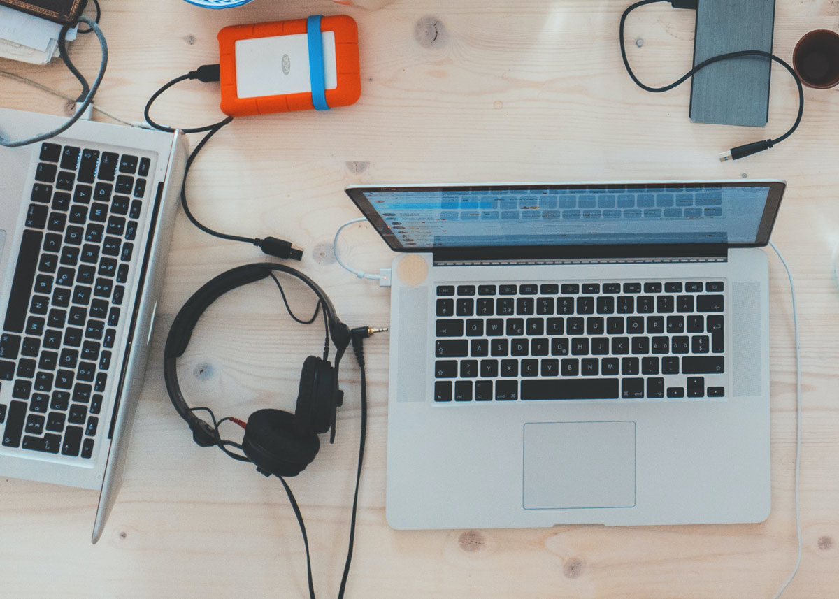 laptop, headphones, and external hard drive on a table