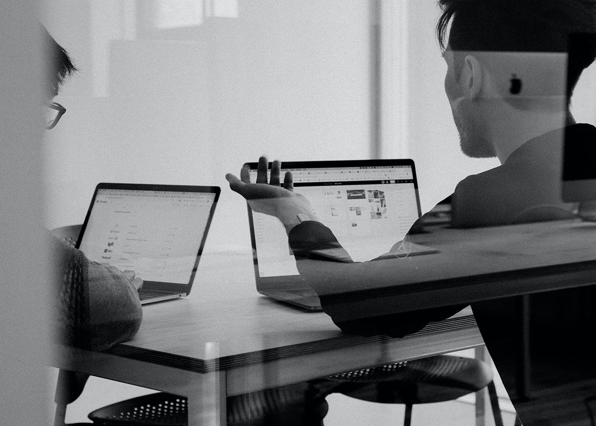 Two people working on laptops in an office