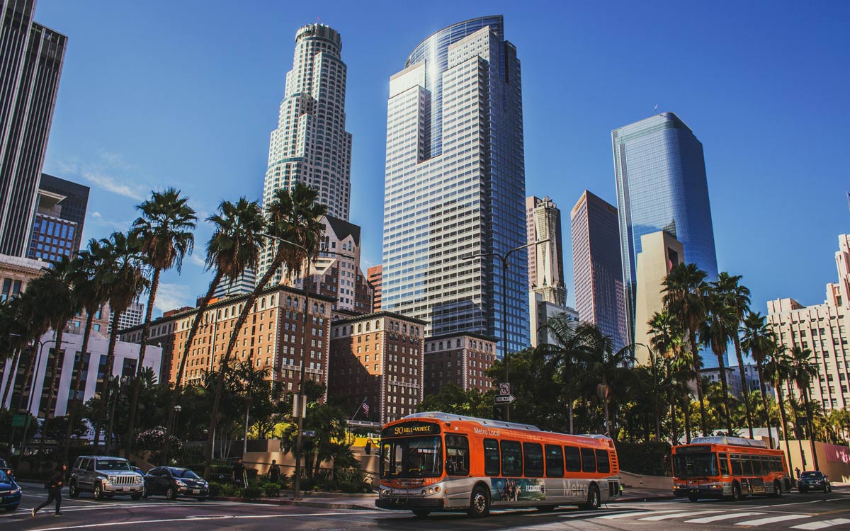 view of a city with buildings, a bus, and trees