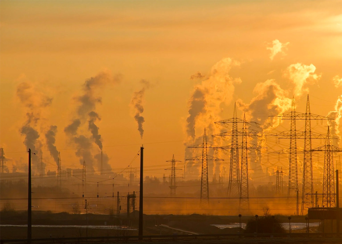 Industrial plant releasing vapors at sunset