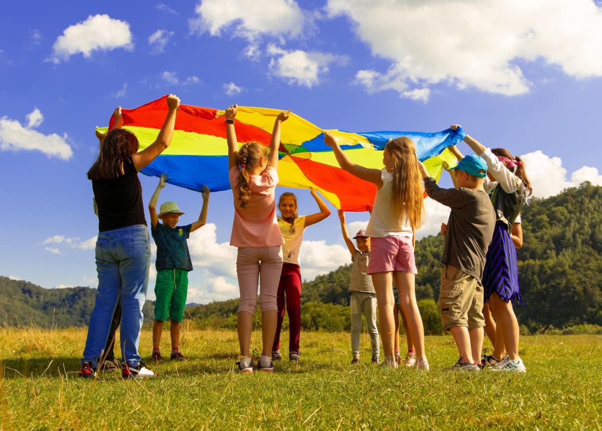 children playing with colorful parachute outside