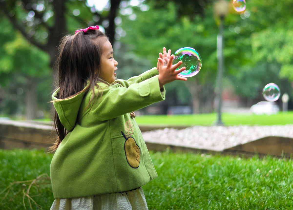 little girl playing with bubbles