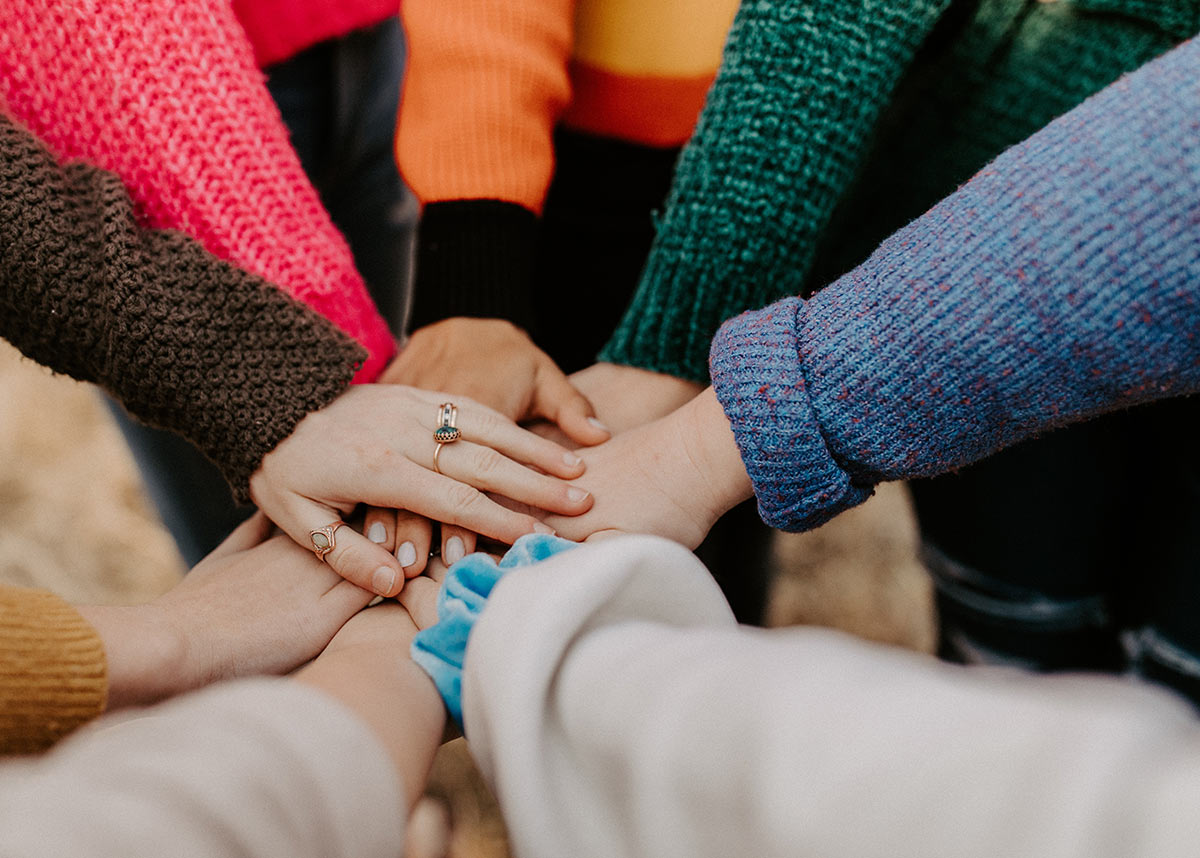 group of hands in on top of one another