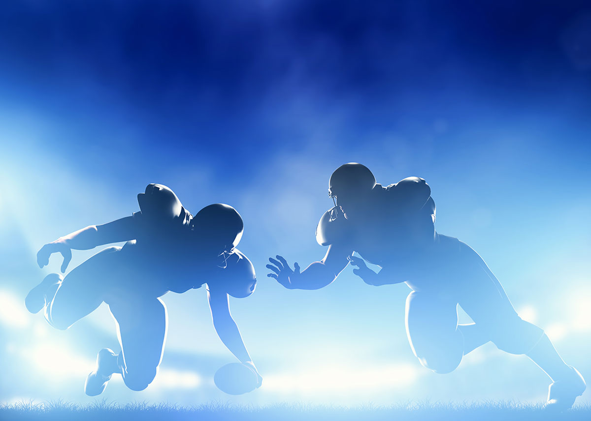 Two backlit football players