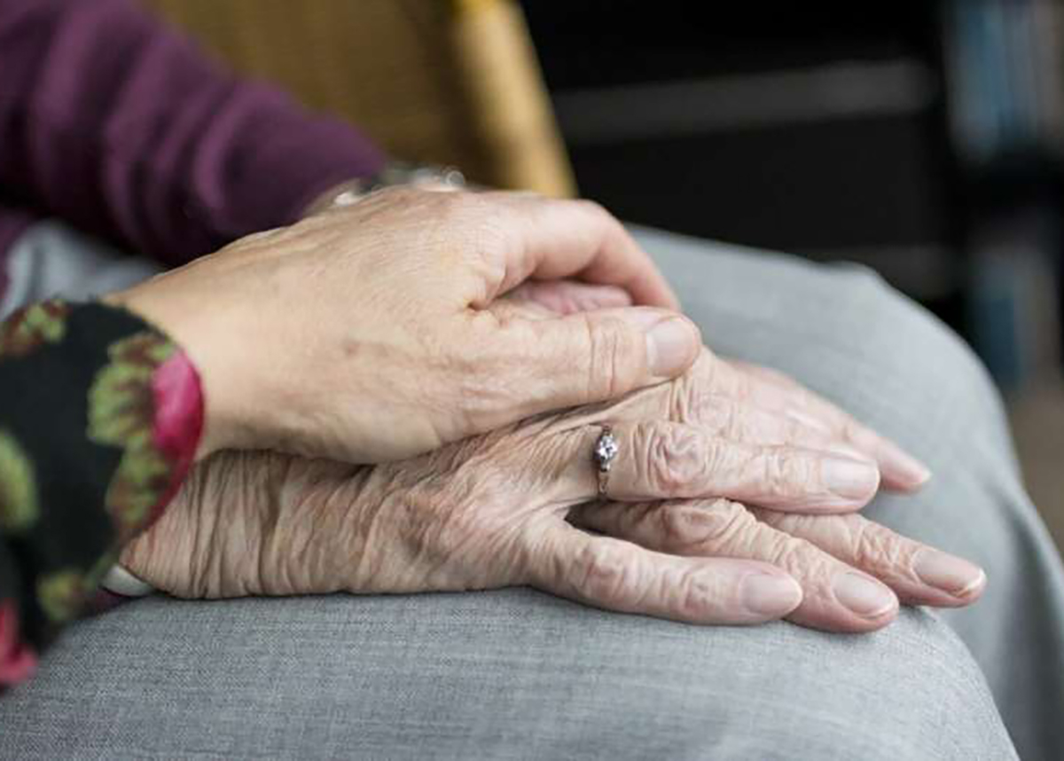 Close up of younger and elderly women holding hands