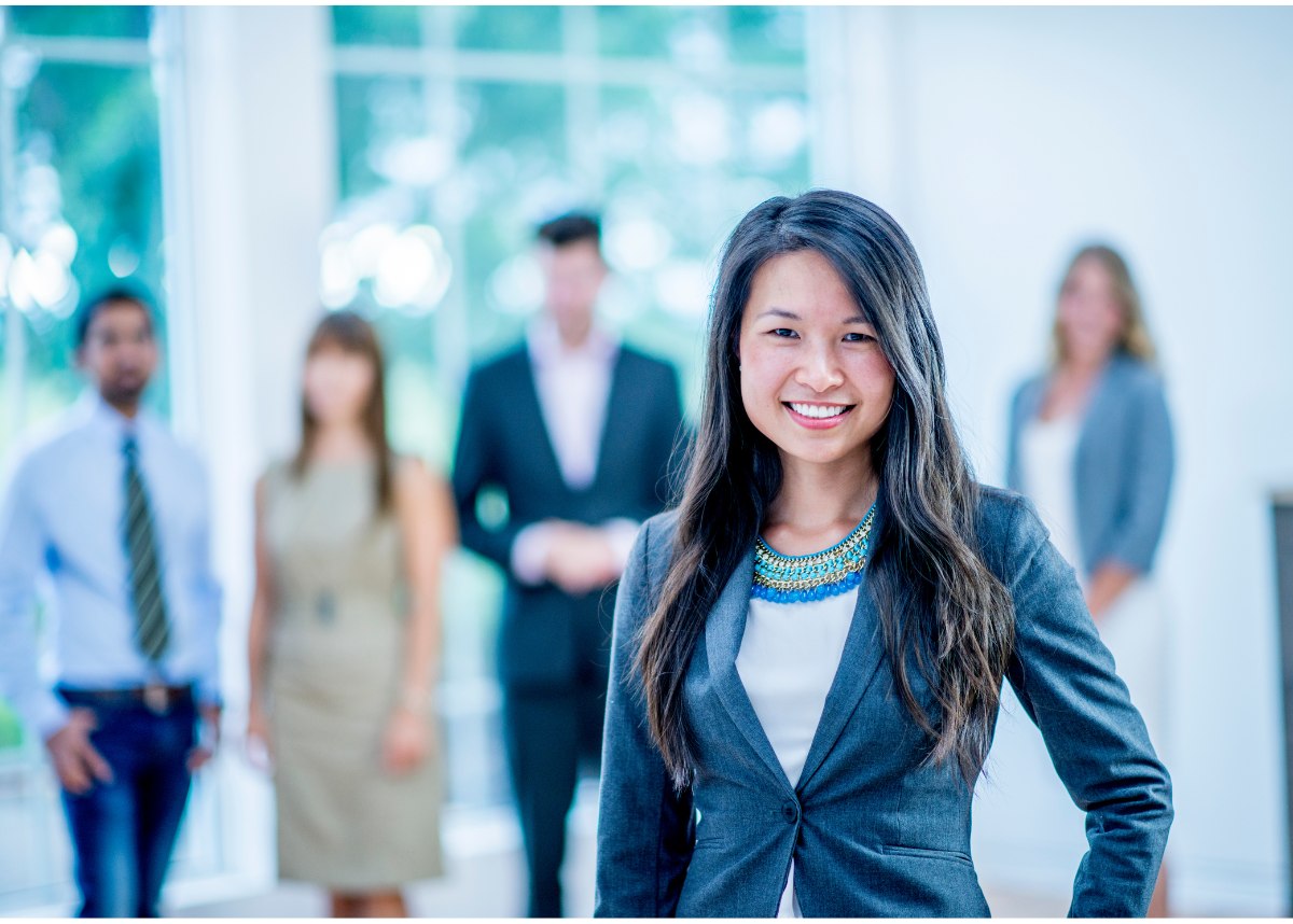 Woman smiling in front of four other blurred out people