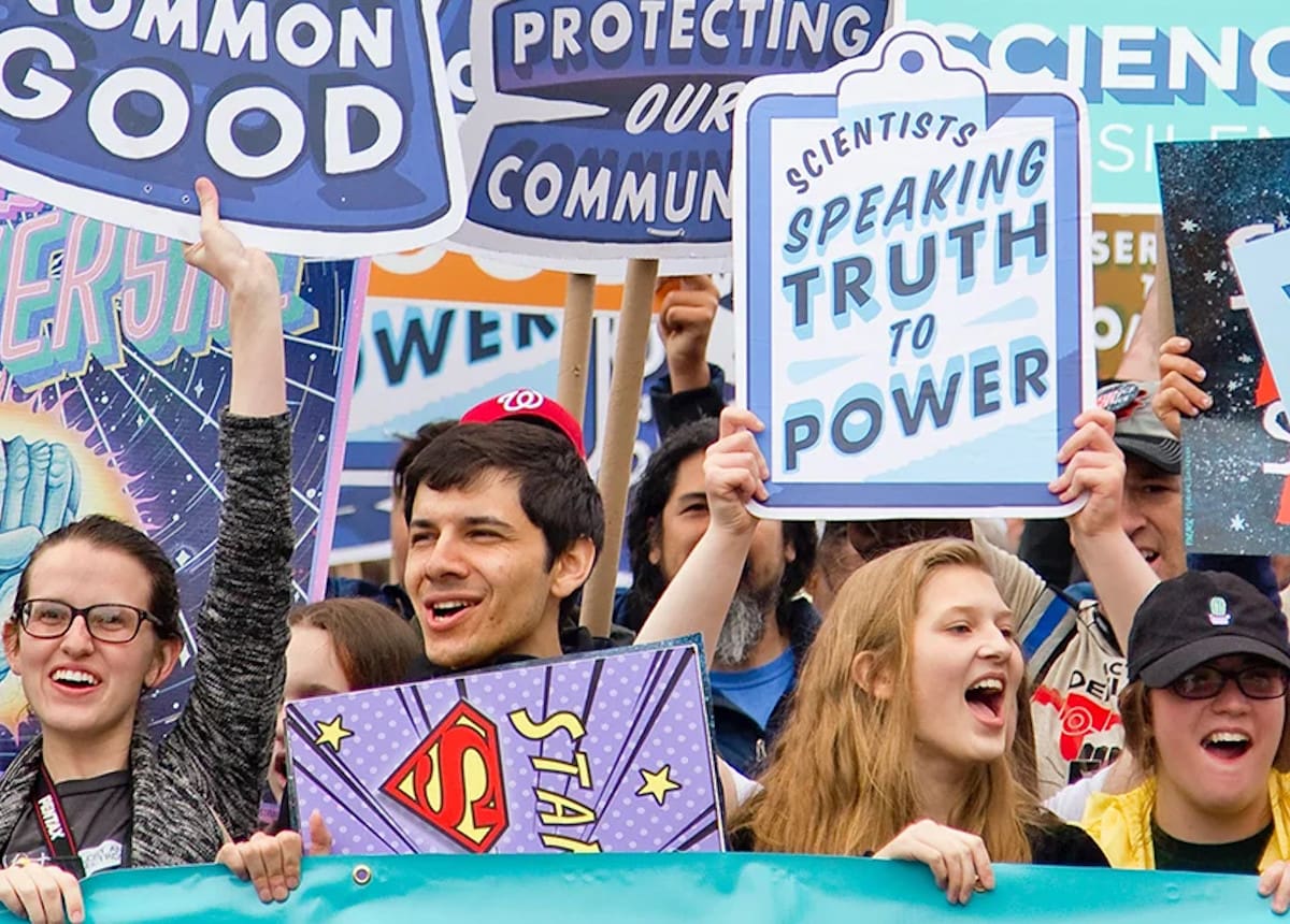 People holding up signs at a rally