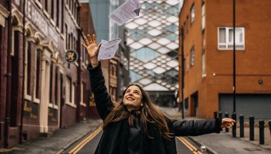 student throwing papers into air