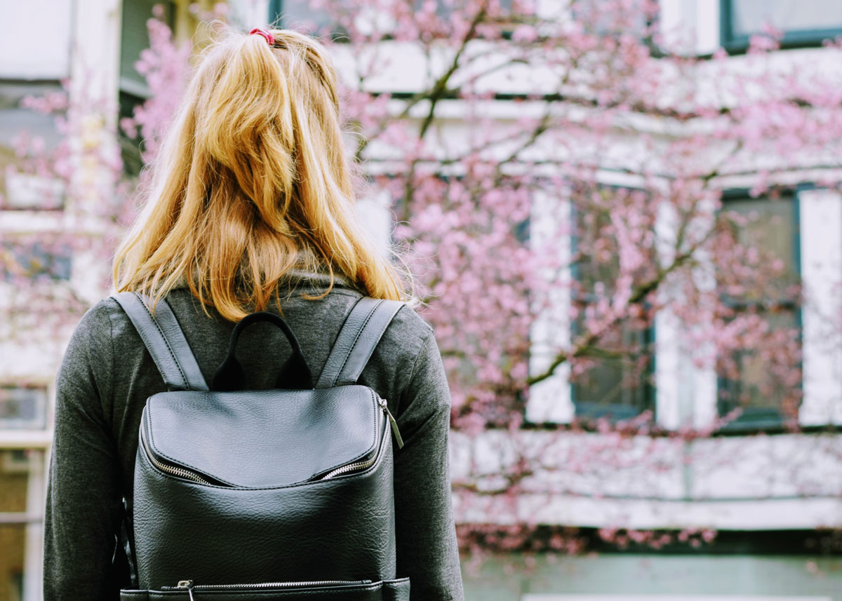 woman with her back turned wearing a backpack