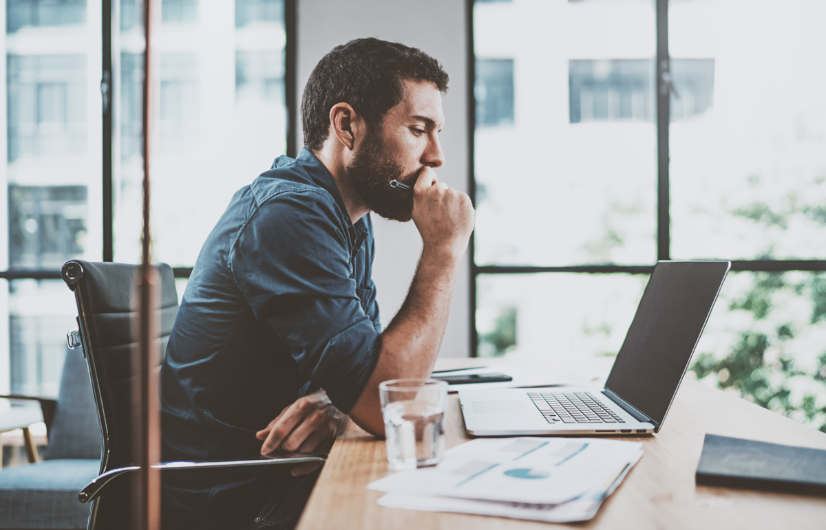 man looking pensive looking at a computer