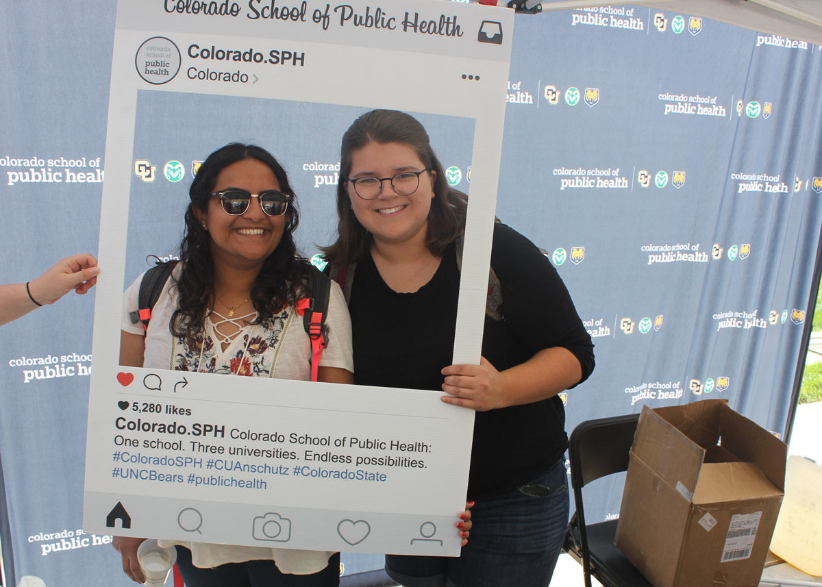 two students with a photobooth prop of an instagram frame