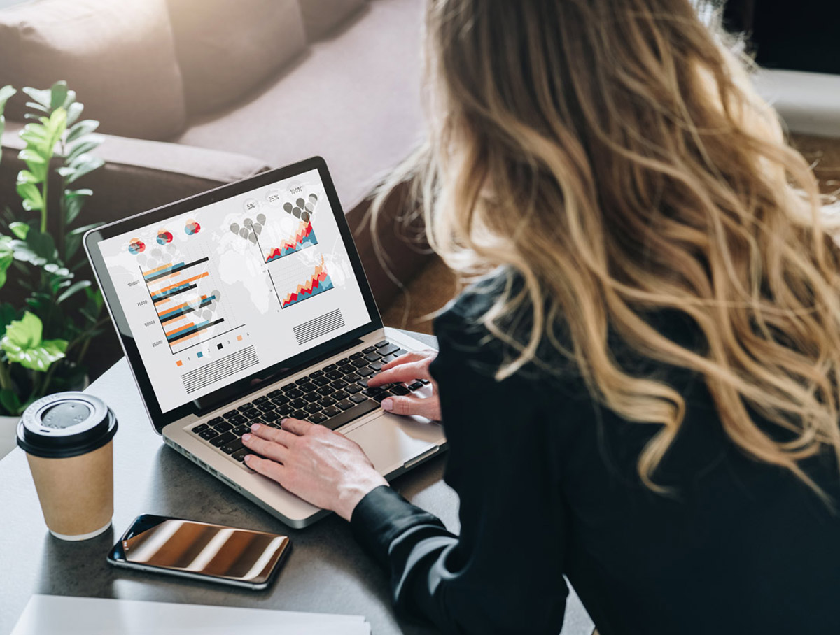 woman working on computer with graphs and charts on screen