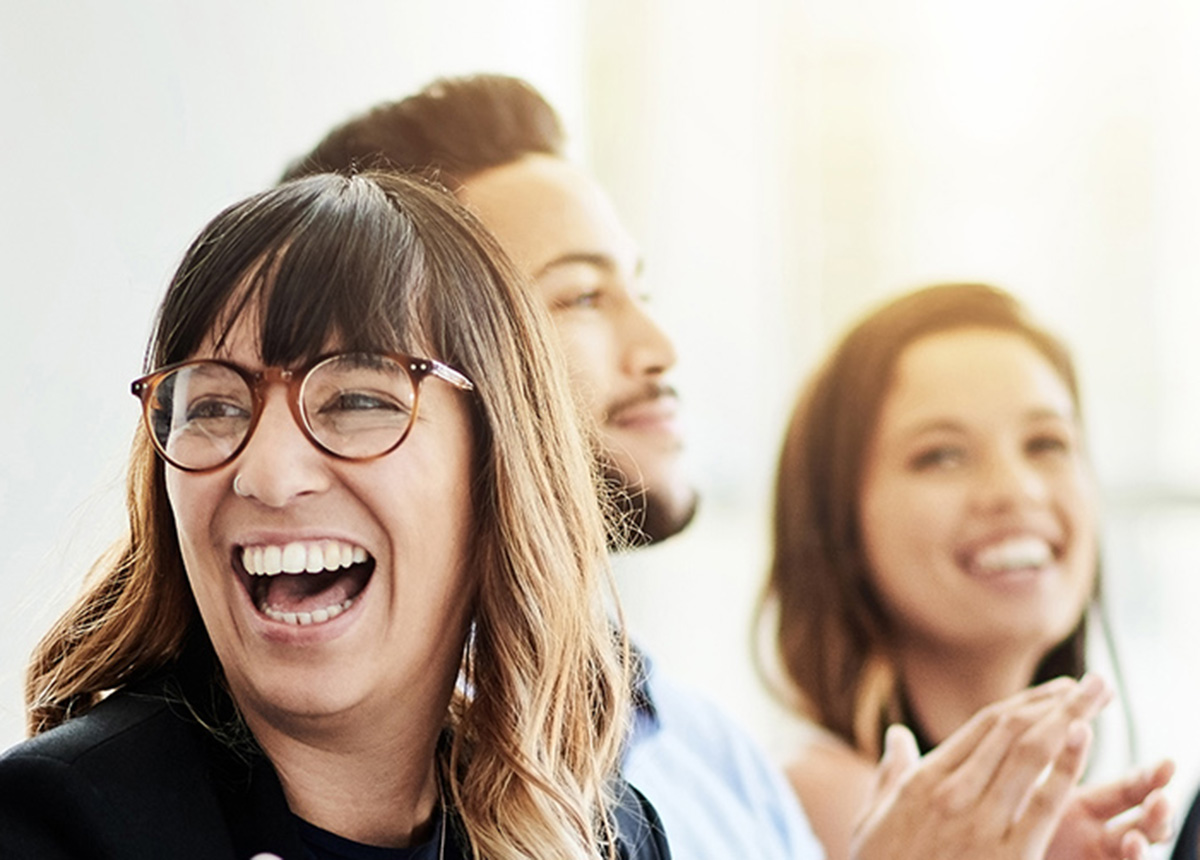 woman laughing and two people smiling in the background