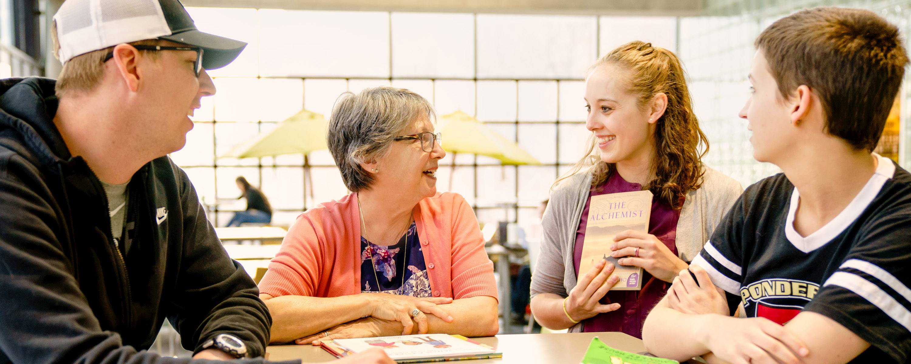 A faculty member explains the meaning of literacy to a small group of students