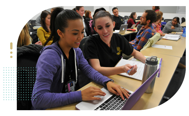 Group of student nurses in college going over notes on computer