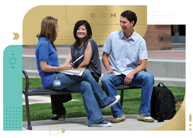 Two female and male college students sitting on bench discussing classroom work