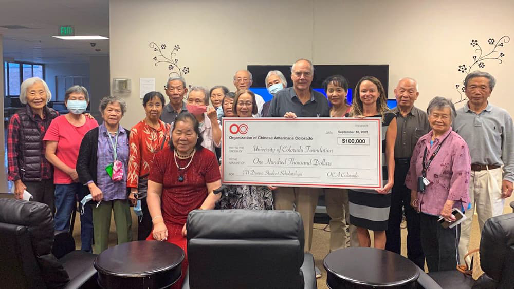 Group of people holding an oversized check for $100,000