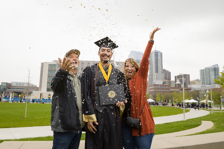 CU Denver student at graduation with friends and family