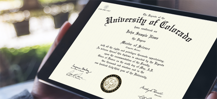 Image of a CU Denver student holding a University of Colorado degree